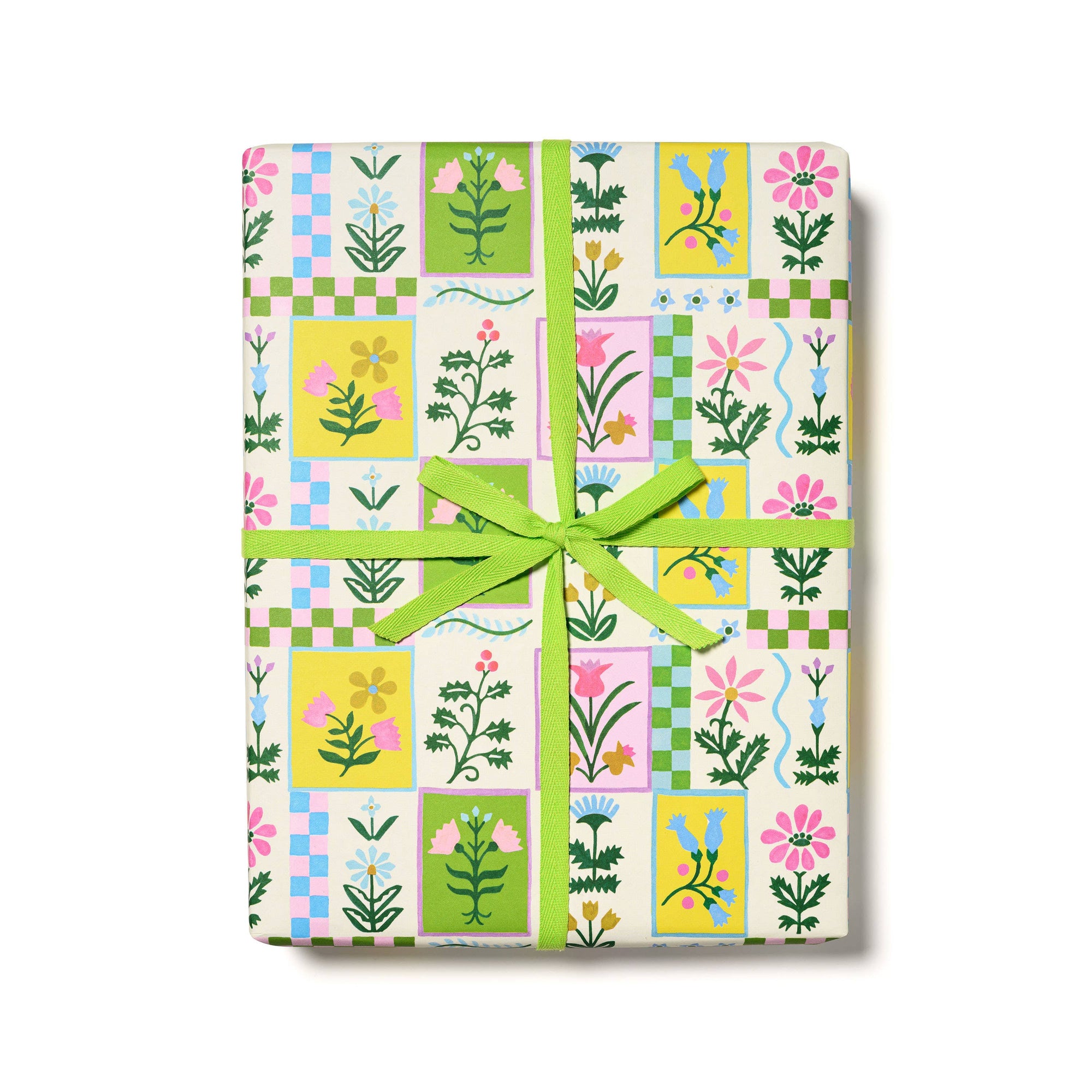 Gift wrap with floral and checkered pattern tied with a green ribbon on a white background