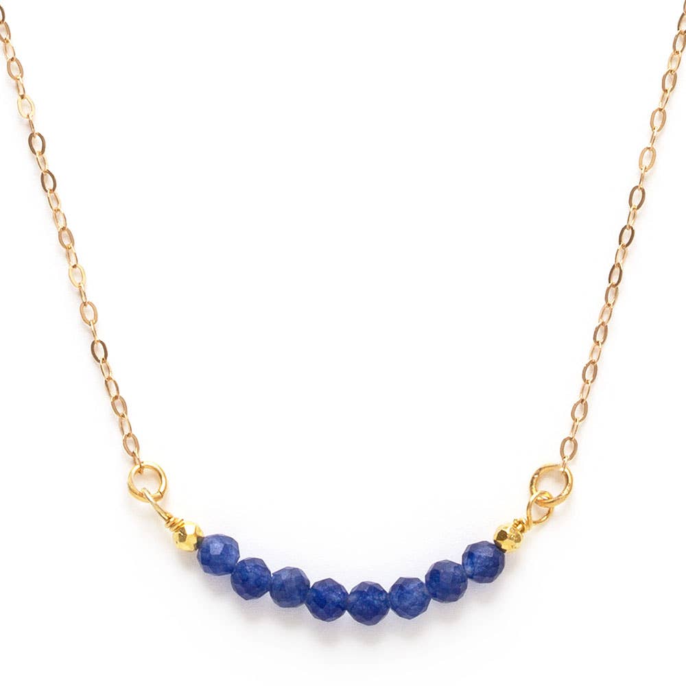 Necklace with blue beads and gold chain on a white background