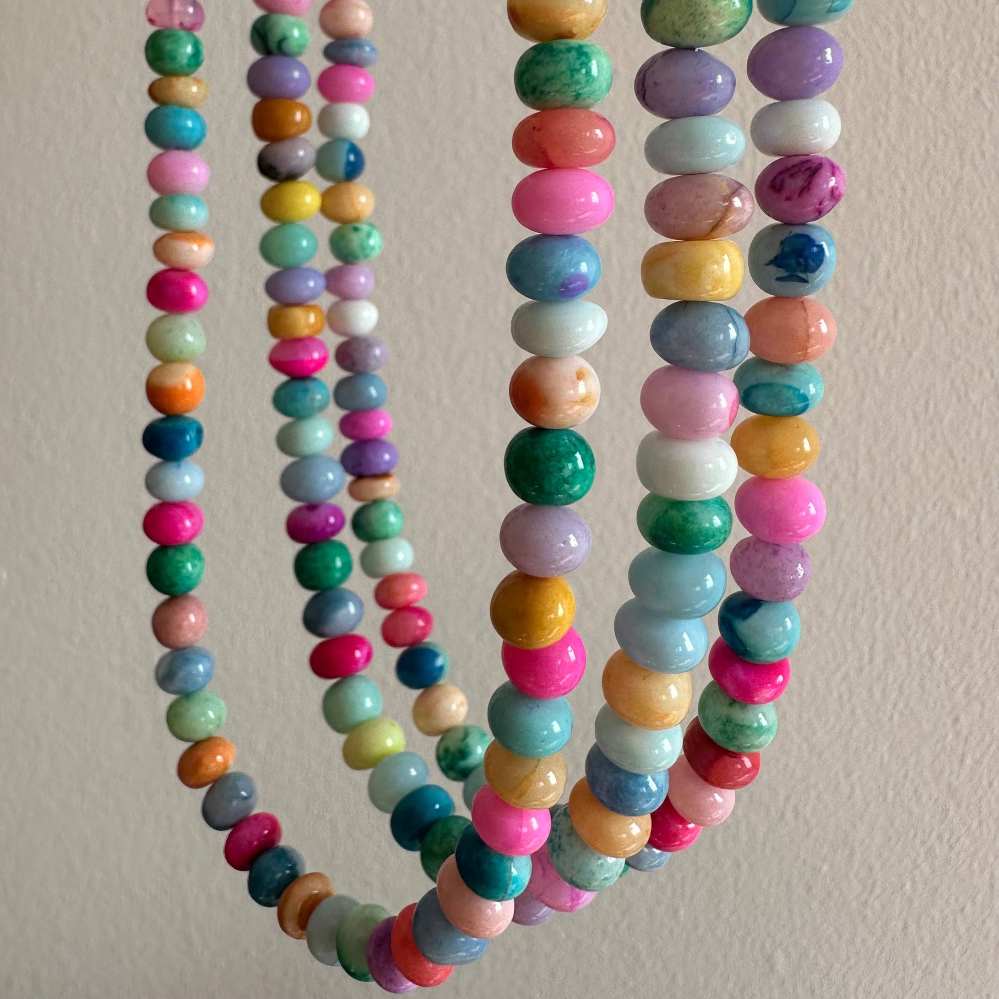 Colorful beaded necklaces on a plain background
