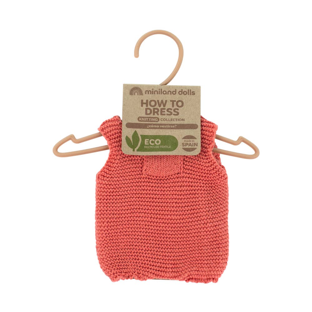 Knitted pink garment on a hanger with 'How to Dress' label on a white background