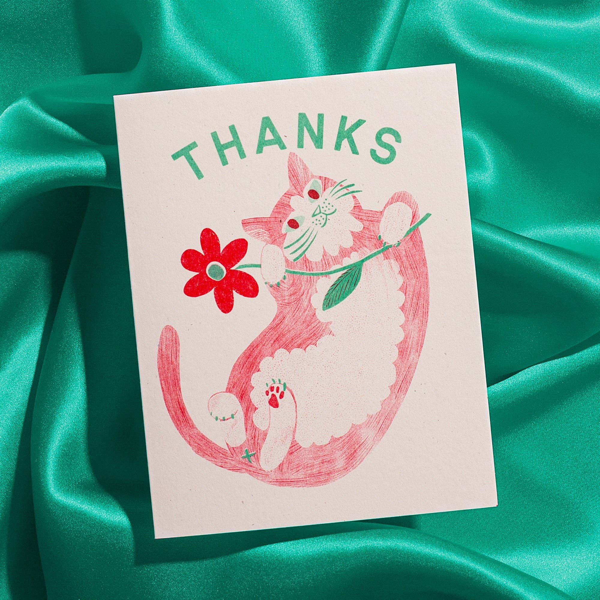 Card with a pink cat illustration and 'THANKS' text on a green fabric background