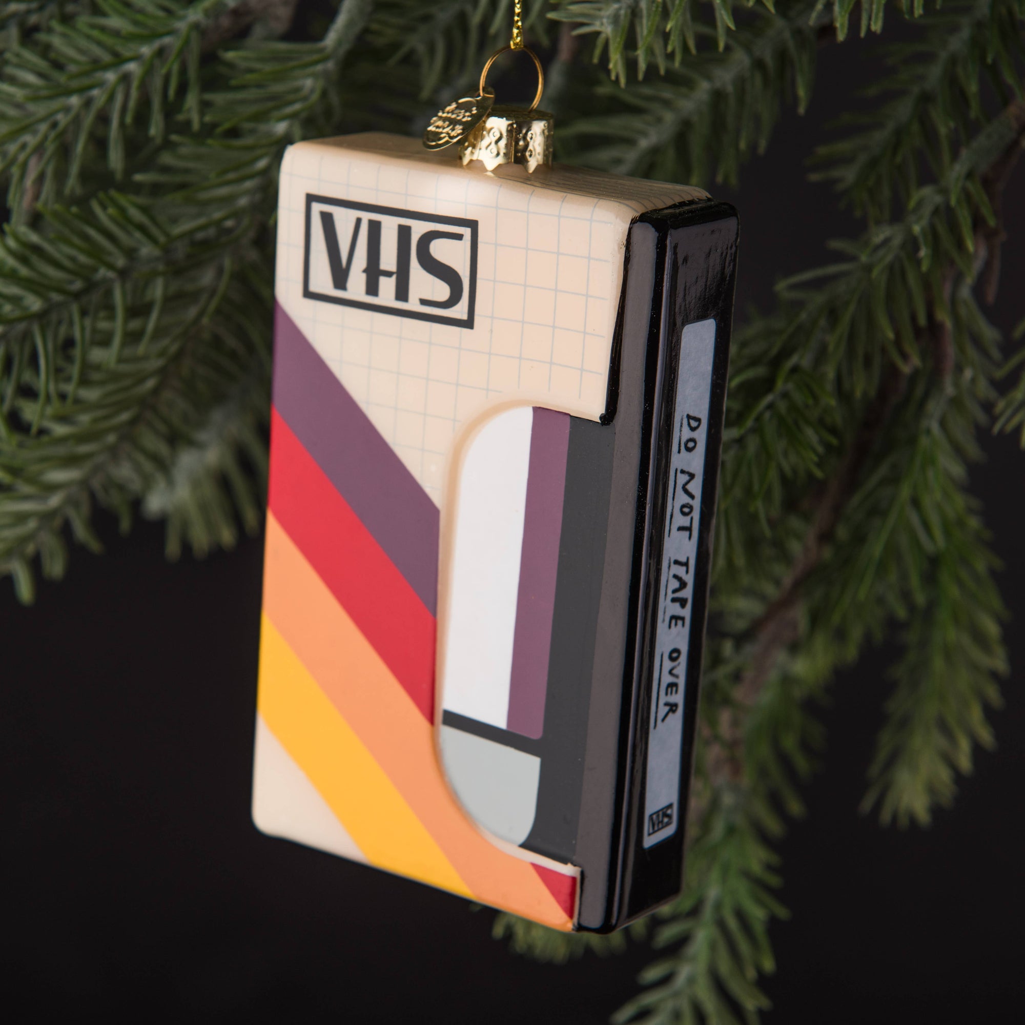 VHS tape ornament with colorful stripes on a green tree background