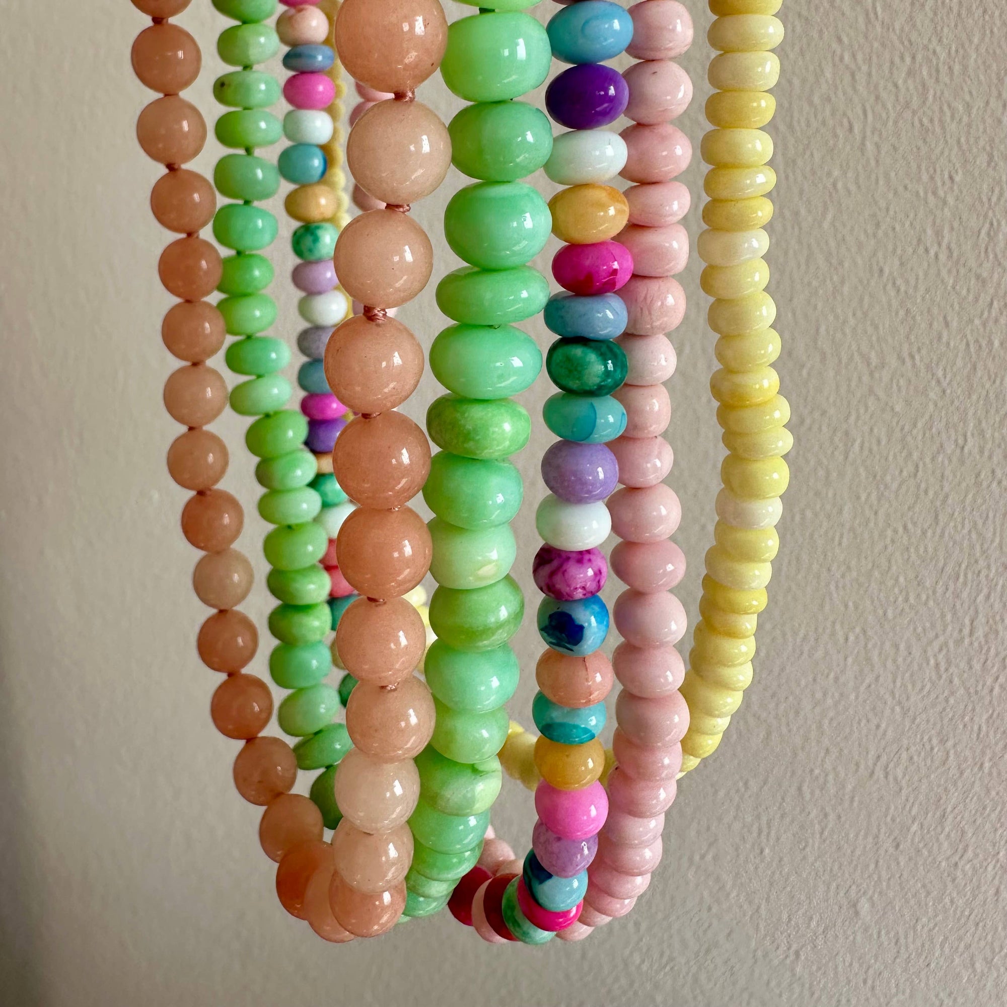 Set of colorful beaded bracelets on a neutral background