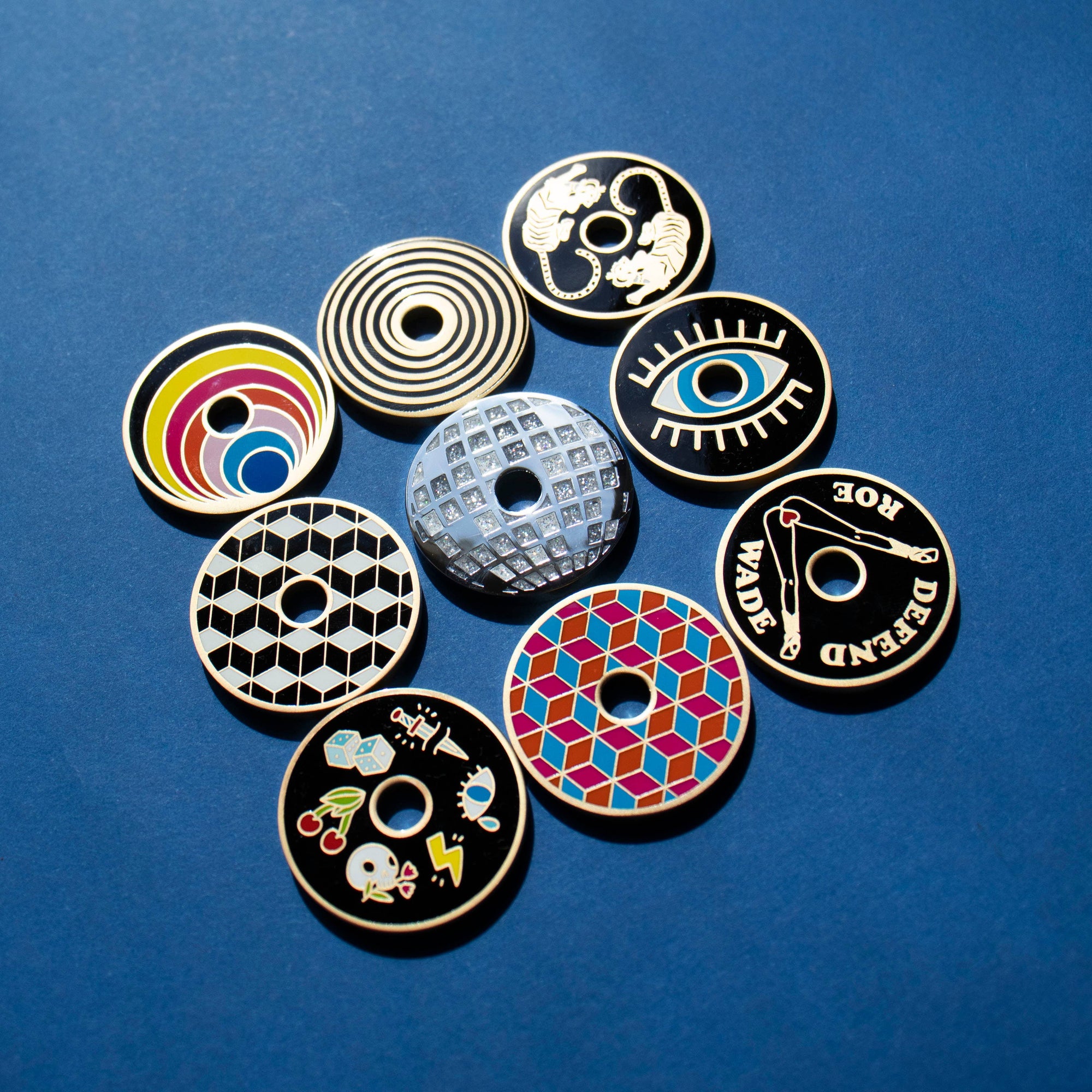 Collection of colorful circular pins with various designs on a blue background