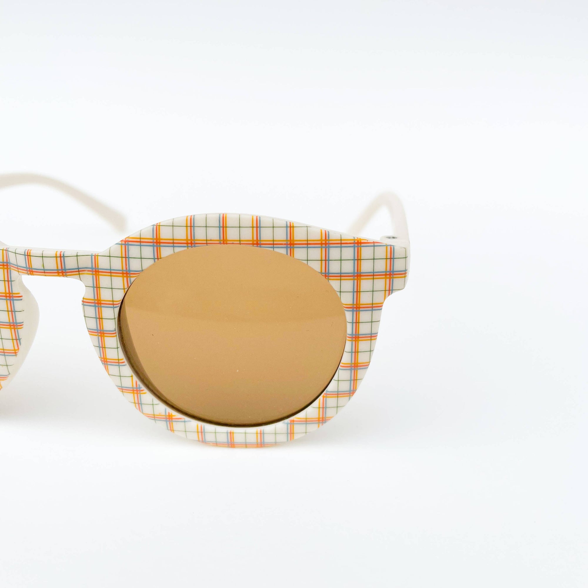 Sunglasses with plaid frame and round mirror lens on a white background