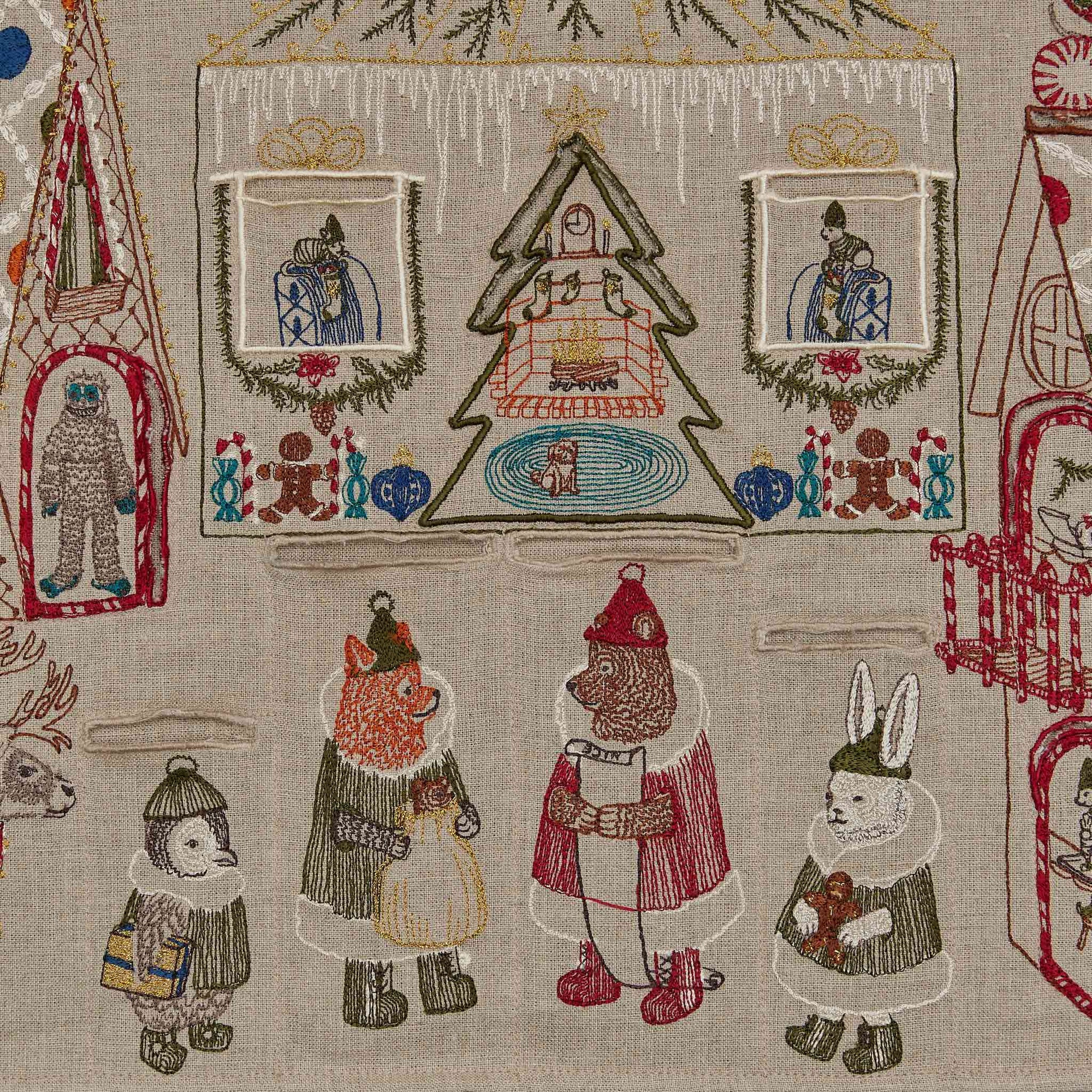 Embroidered fabric with winter-themed designs including animals in winter clothing and a Christmas tree.