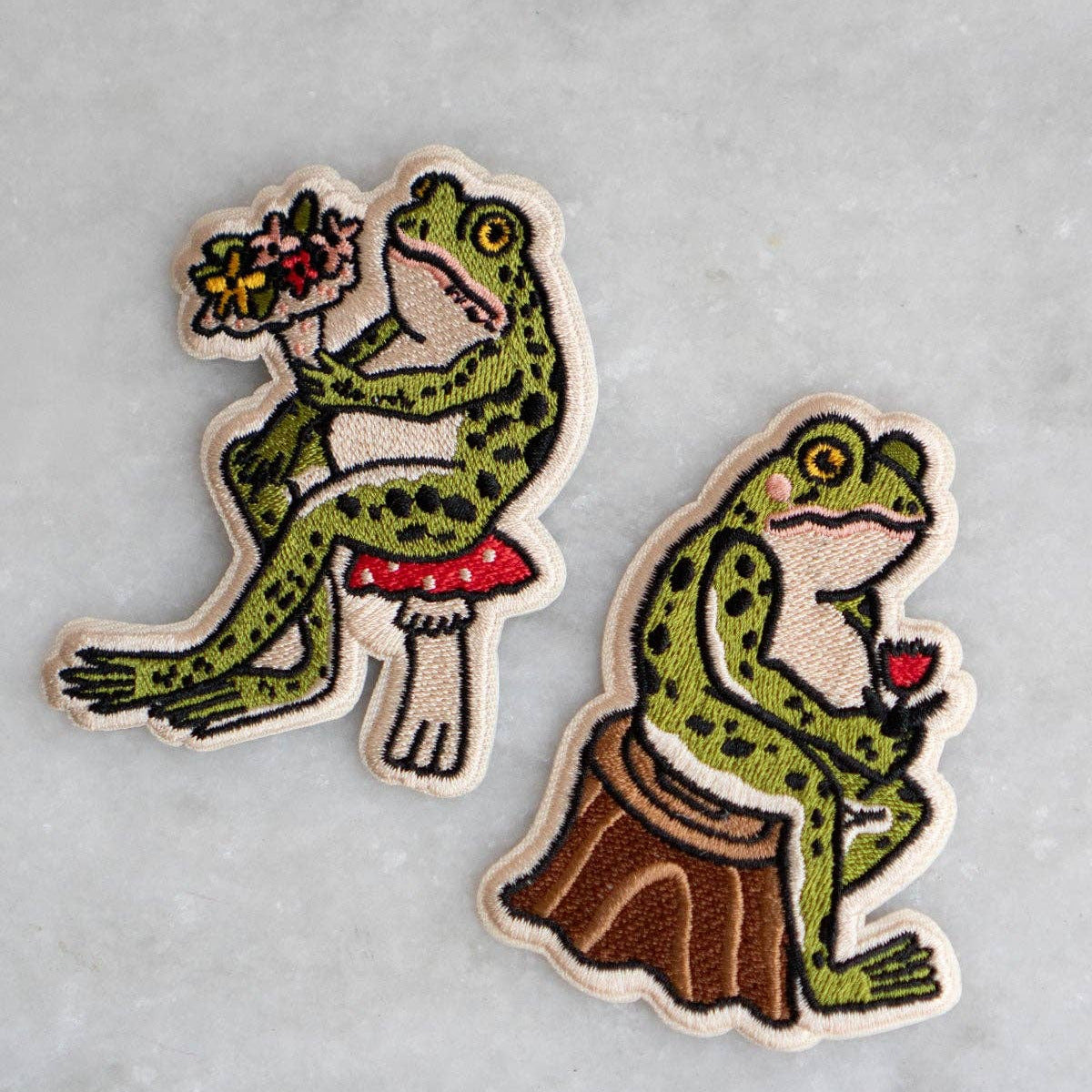 Two frog-themed patches on a gray background