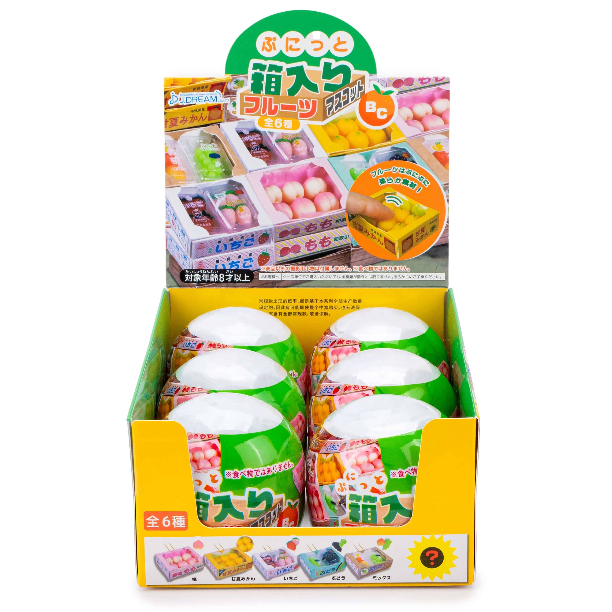 Display box of small toy figures with colorful packaging and Japanese text.