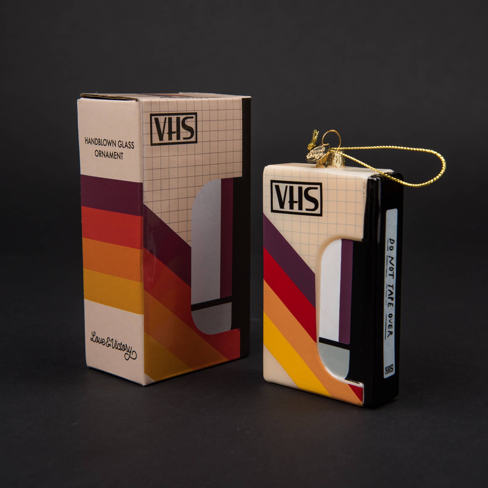 VHS tape ornament with packaging on a black background