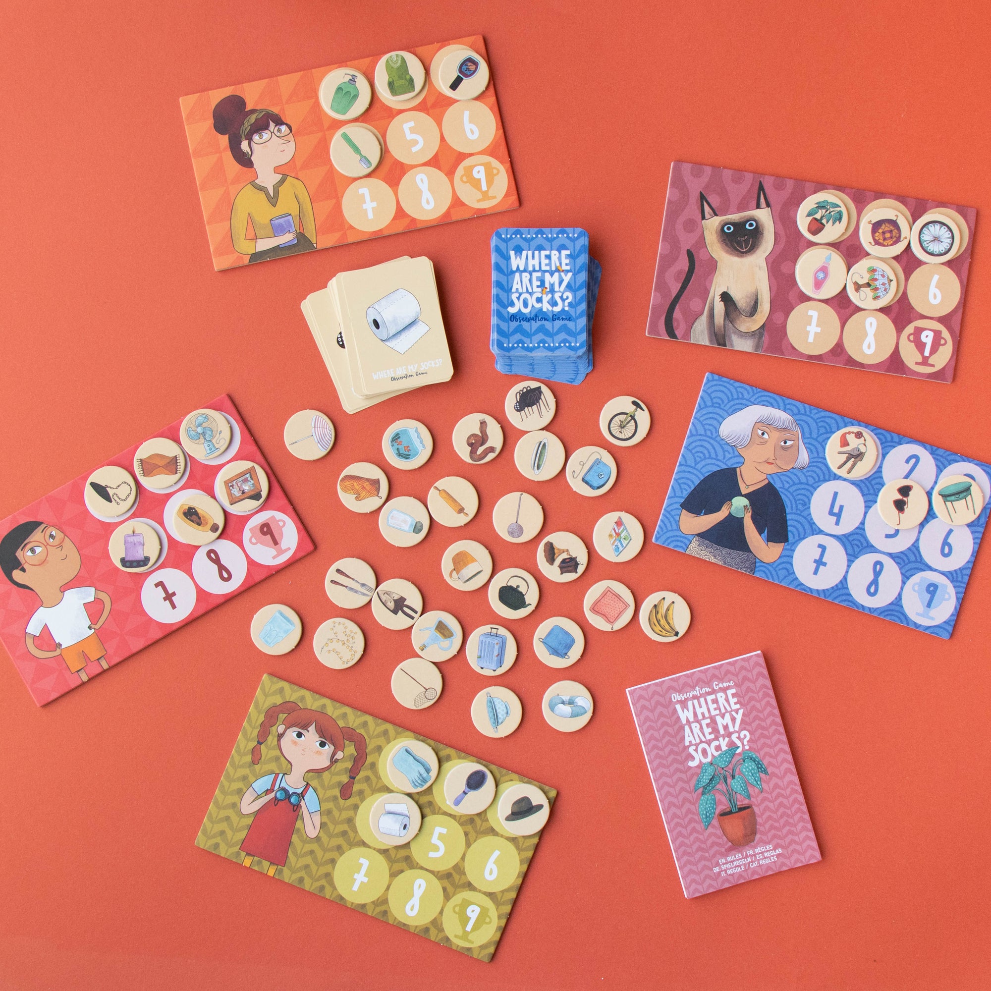 Board game components including cards and tokens on an orange background