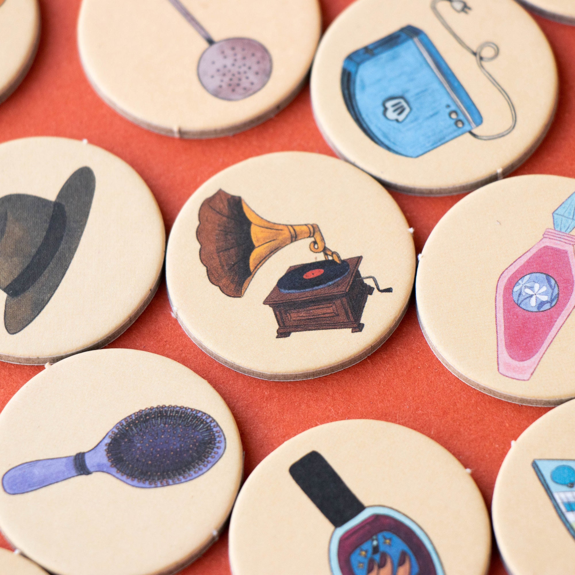 Collection of round coasters with various illustrations on a red surface