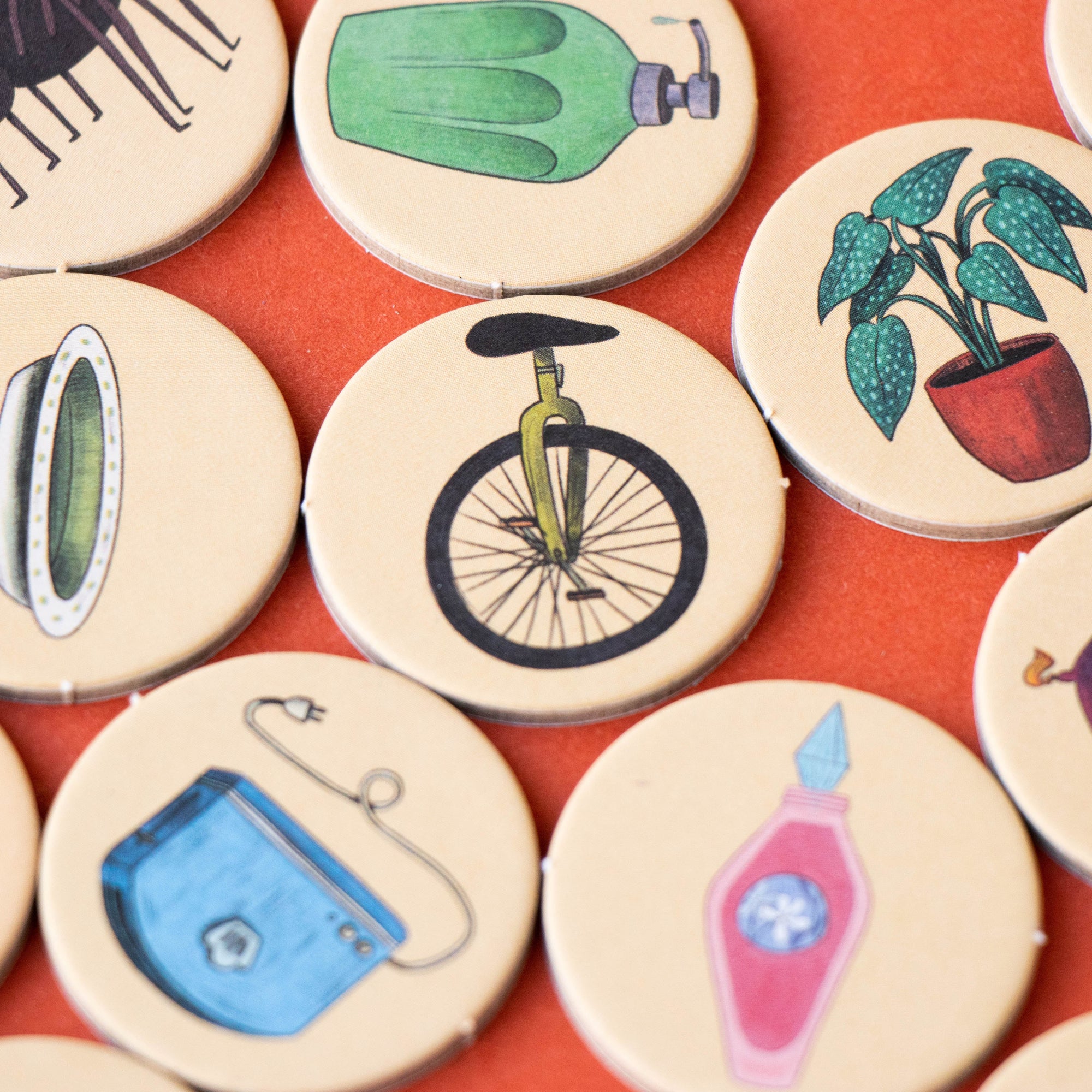 Set of round ceramic coasters with various illustrations on a red surface