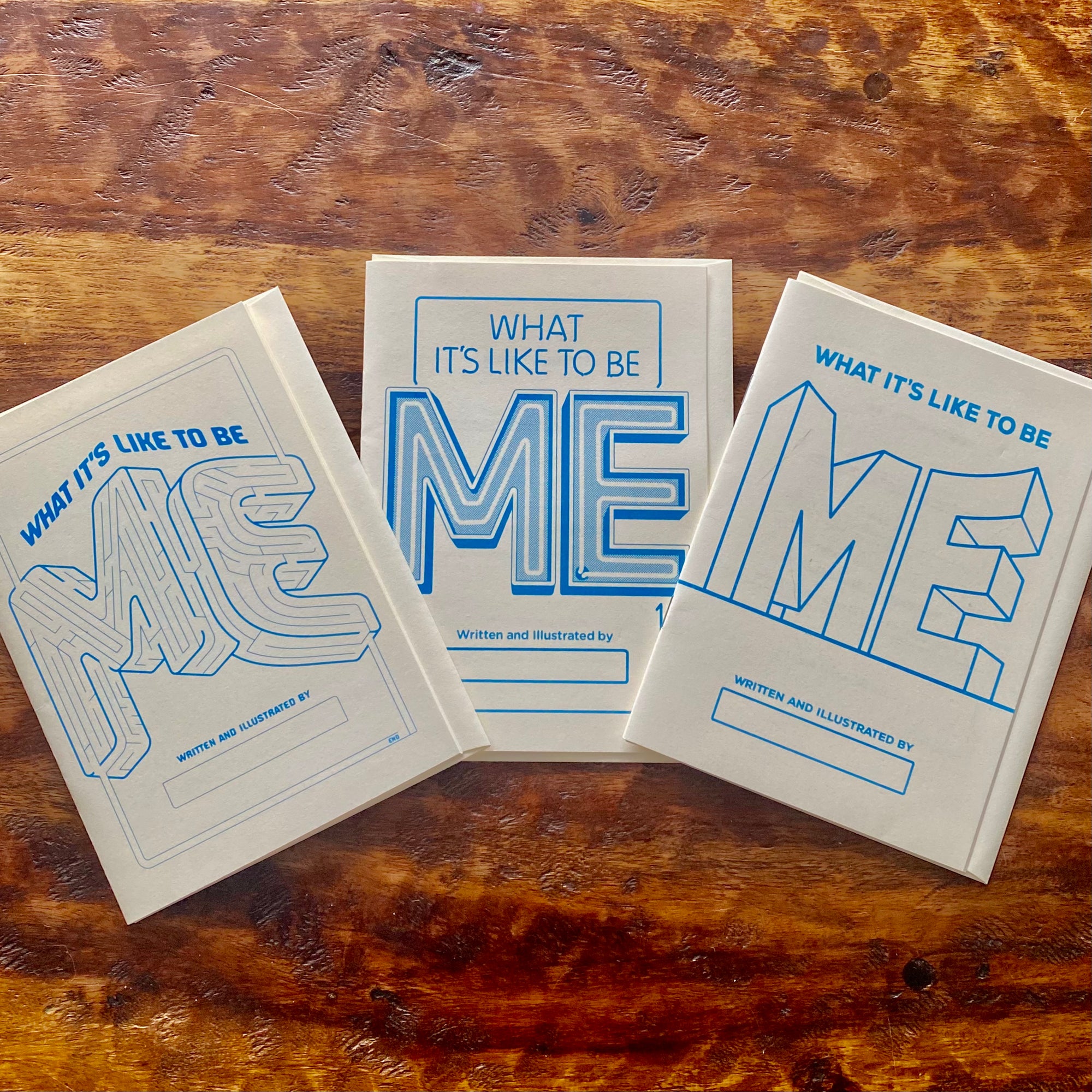 Three books titled 'What It's Like to Be Me' on a wooden surface