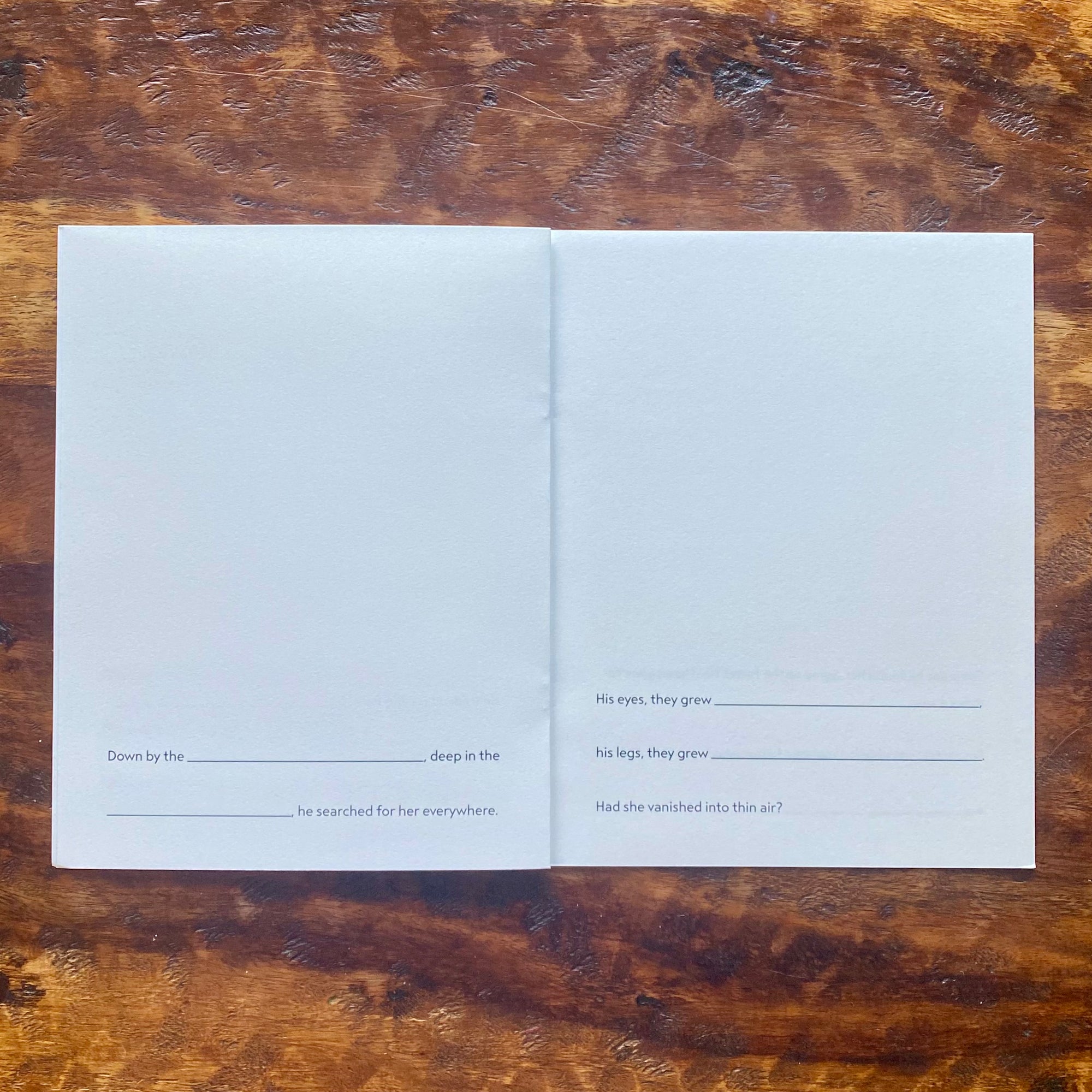 Open book with blank pages on a wooden surface