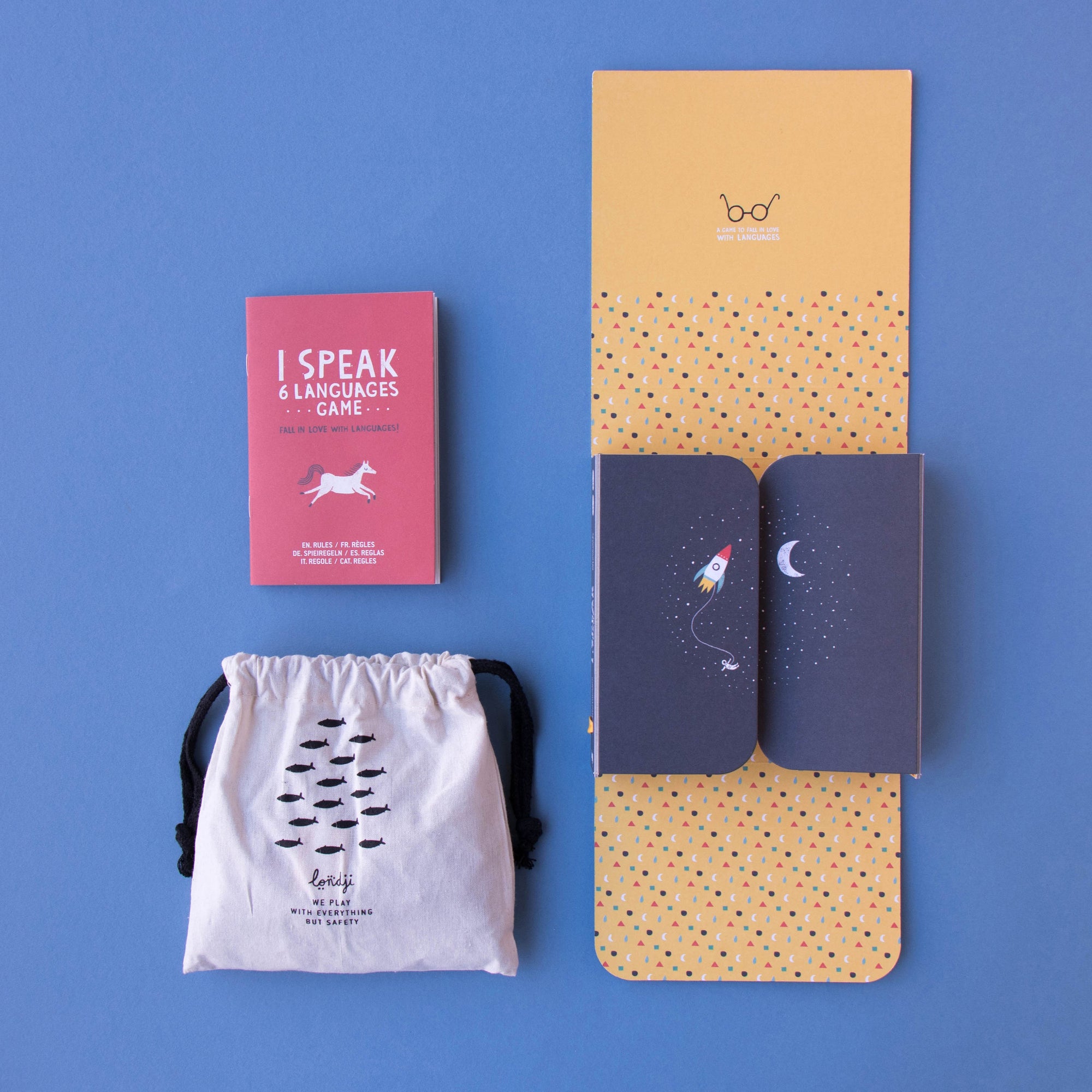 Product packaging with a pink card, white drawstring bag, and two notebooks on a blue background
