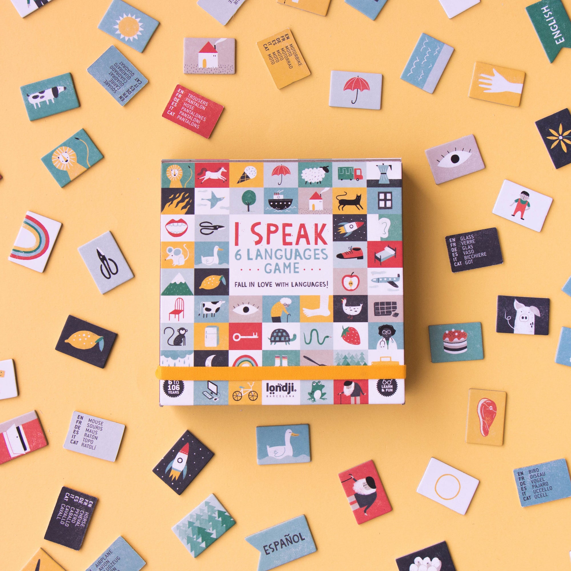 Board game box titled 'I Speak X Languages' surrounded by various language cards on a yellow background