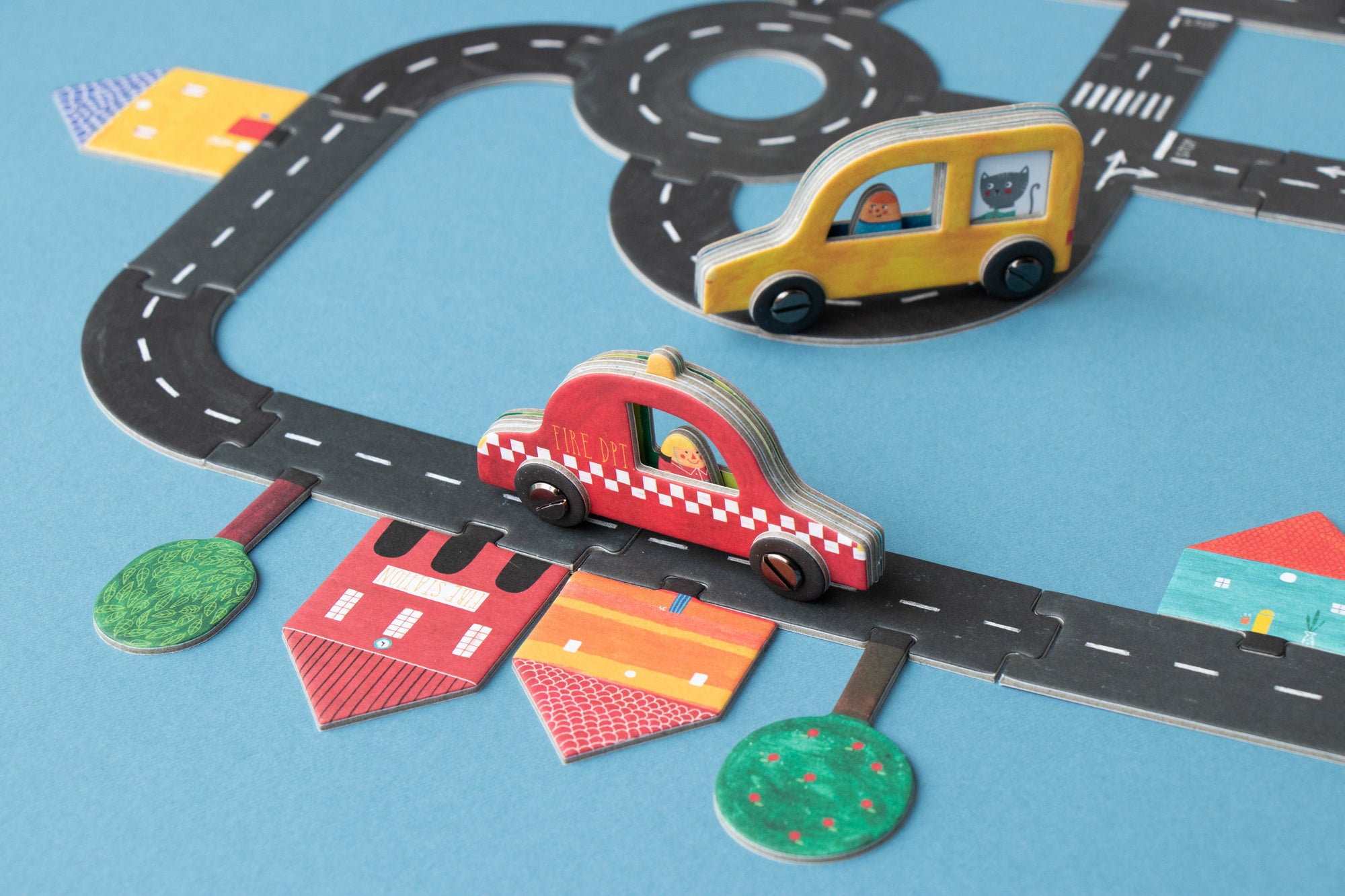 Toy cars on a paper road map with traffic lights and other elements on a blue background