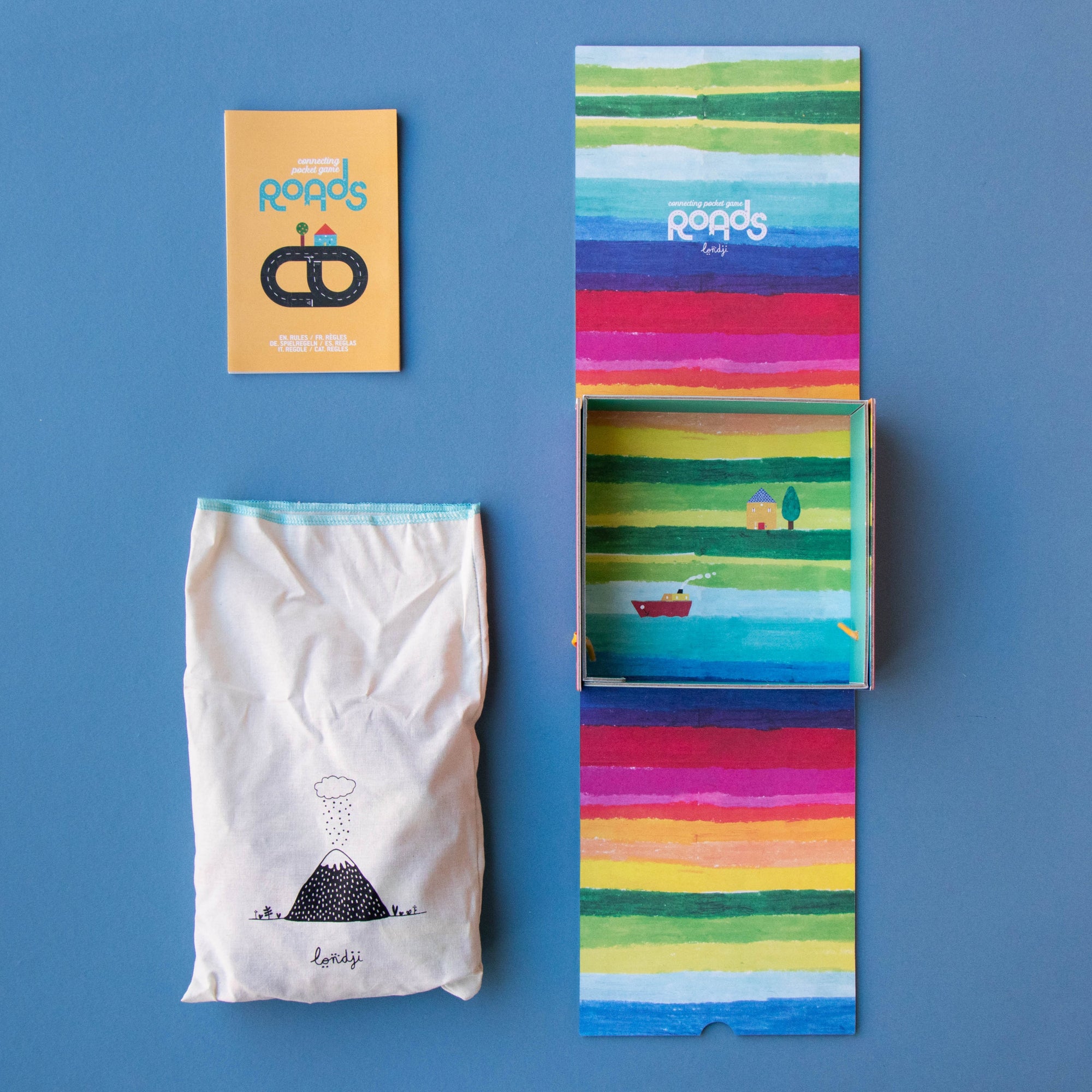 Colorful packaging with a small card, bag, and box on a blue background