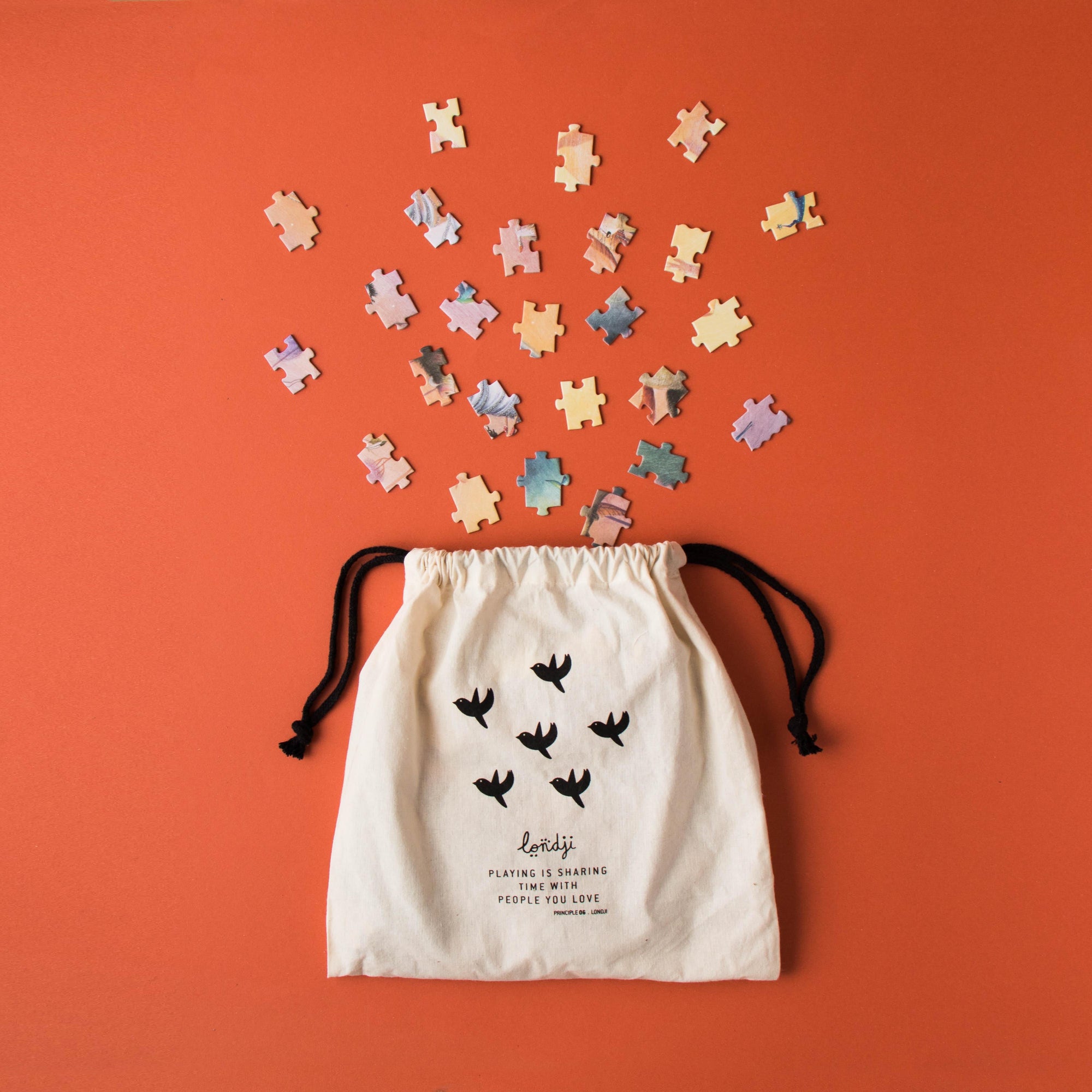 Drawstring bag with puzzle pieces on an orange background