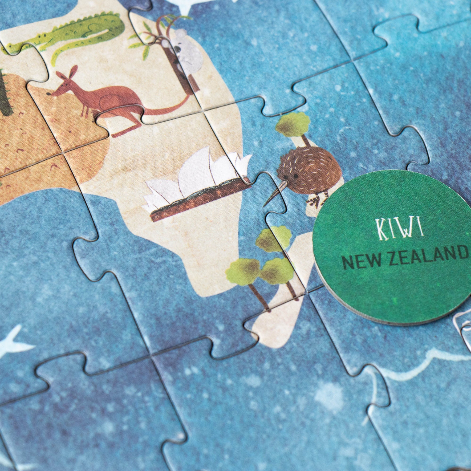 Jigsaw puzzle of New Zealand with a 'Kiwi New Zealand' badge