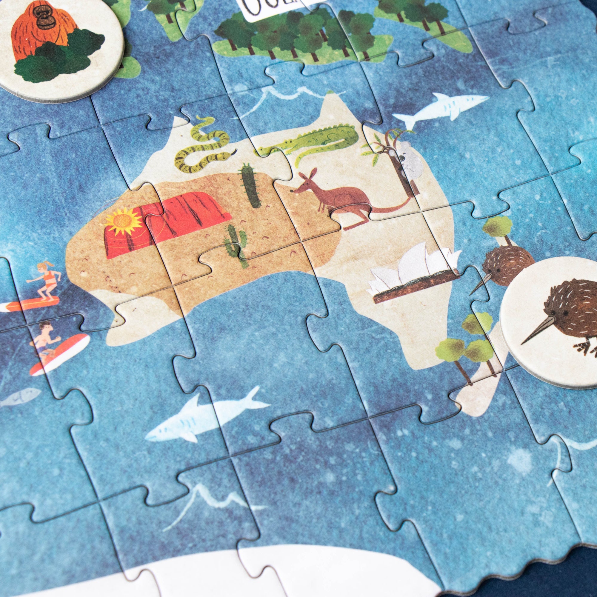 Jigsaw puzzle of Australia with illustrated elements on a blue background