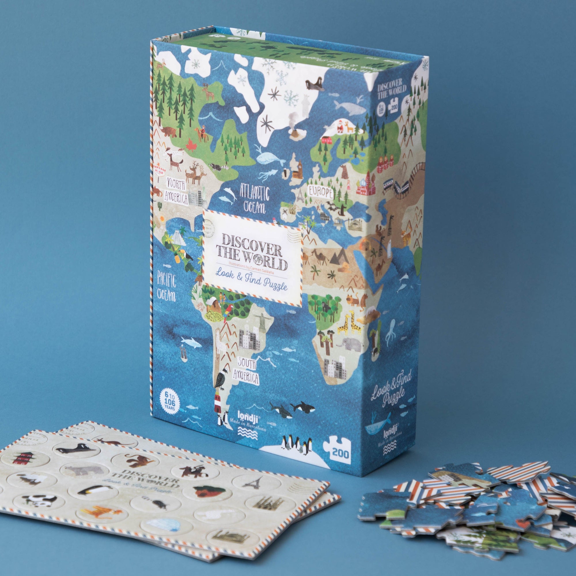 World map-themed puzzle set with box and scattered pieces on a blue background