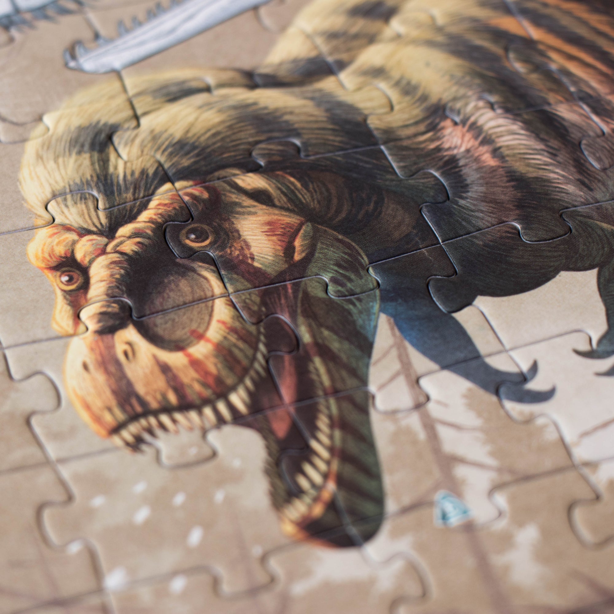 Jigsaw puzzle with a dinosaur design on a wooden surface