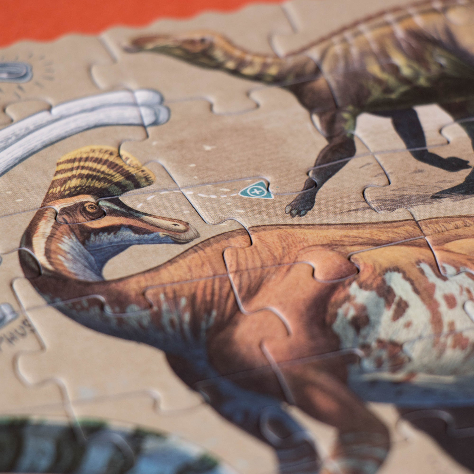 Dinosaur puzzle with partially completed pieces on a red surface