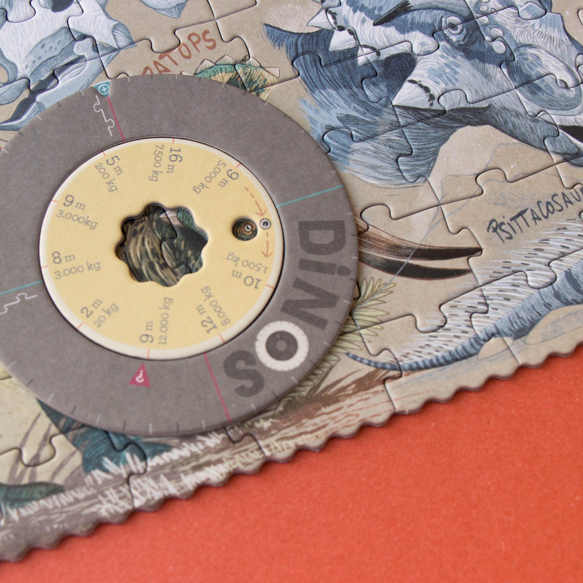 Jigsaw puzzle with dinosaur design and a circular component on top