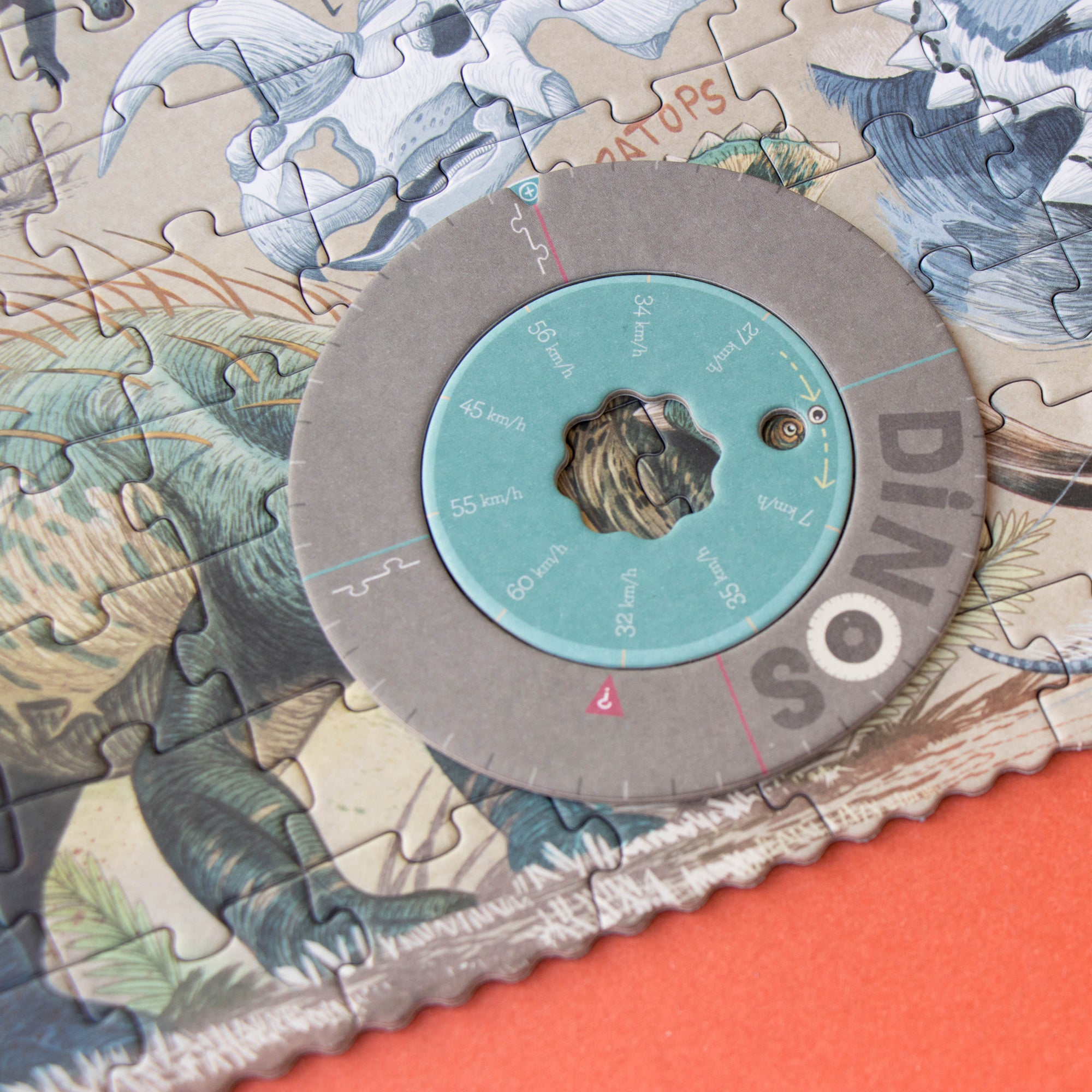 Dinosaur puzzle with a partially completed circular section on an orange surface