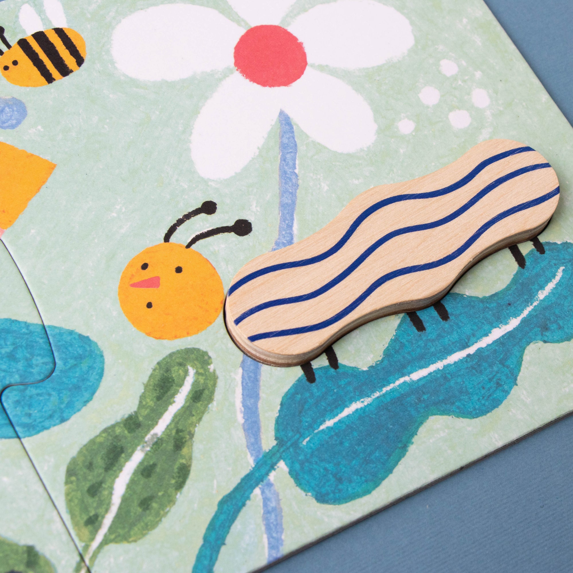 Children's puzzle with a caterpillar piece on a floral background