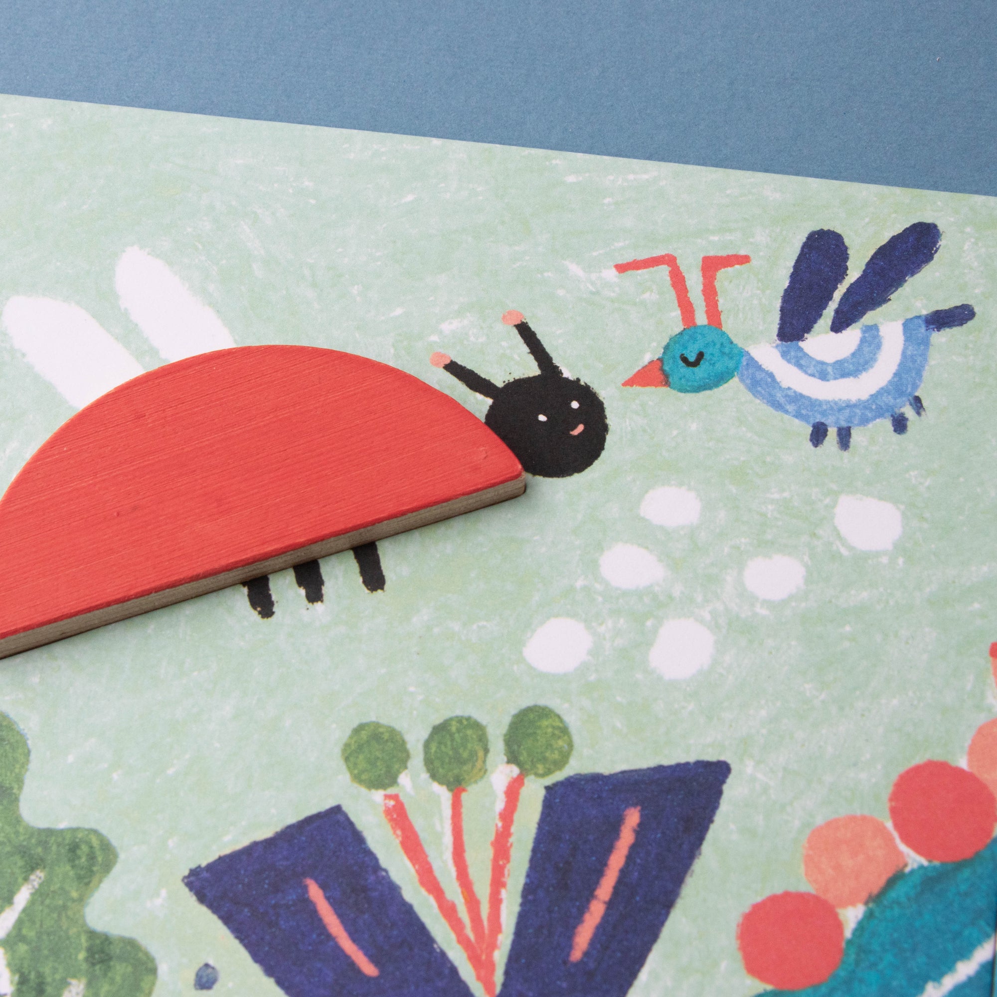 Children's puzzle with illustrations of a ladybug, bird, and caterpillar on a blue background