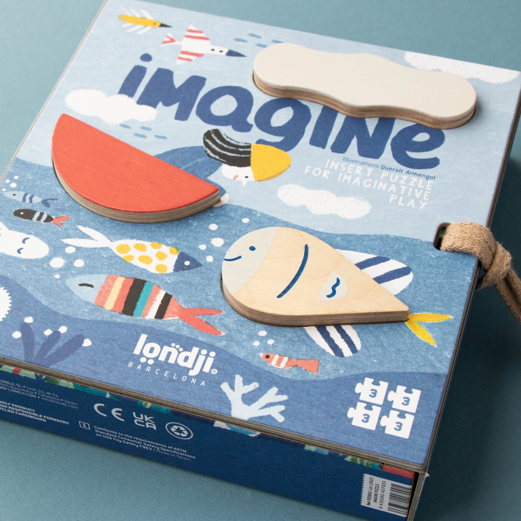 Box of 'Imagine' wooden toys with colorful illustrations on a blue background