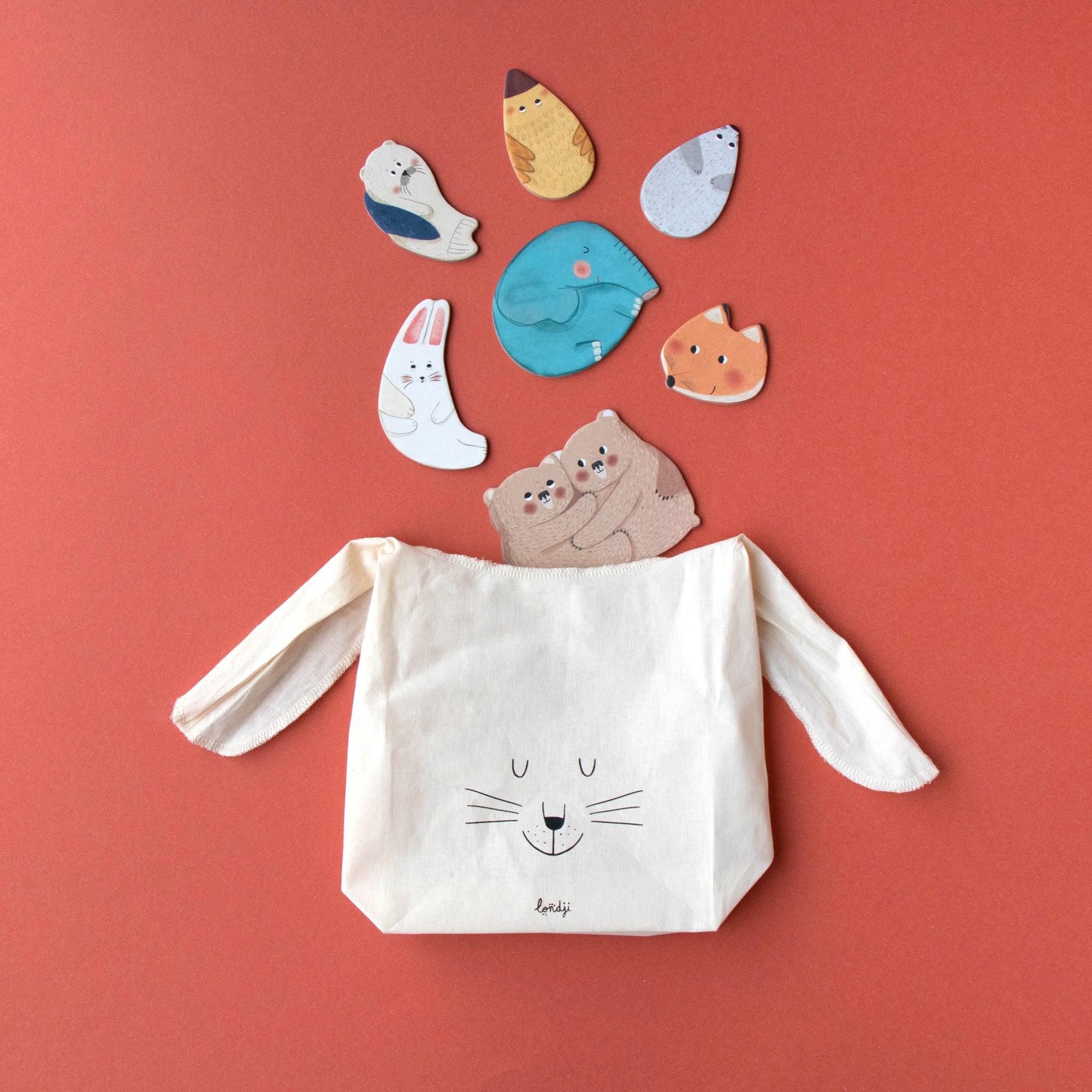 Canvas bag with cat face design and cat-shaped stickers on a red background