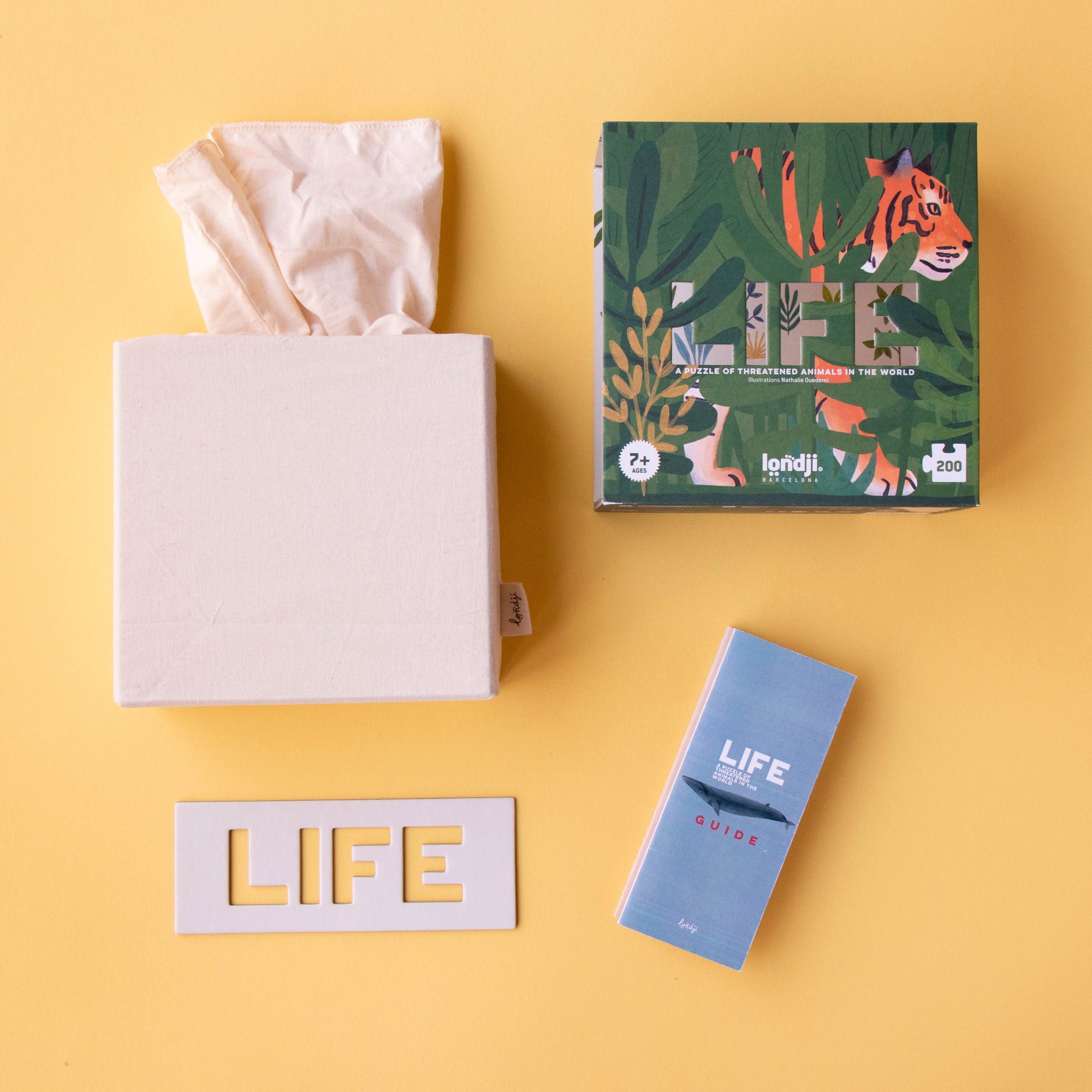 Tissue box, tissue paper, and 'LIFE' branded products on a yellow background