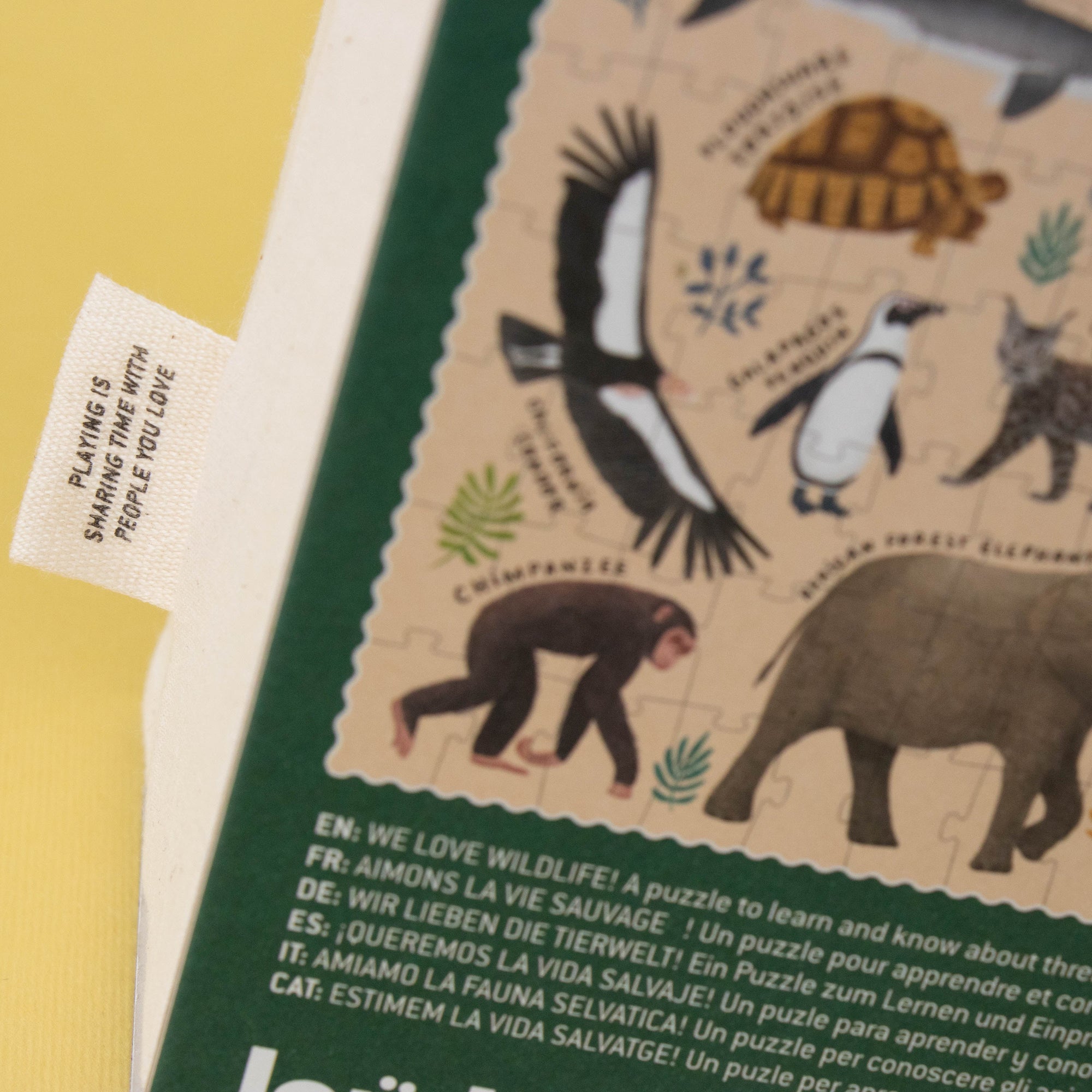 Educational puzzle packaging with animal illustrations and a tag on a yellow background