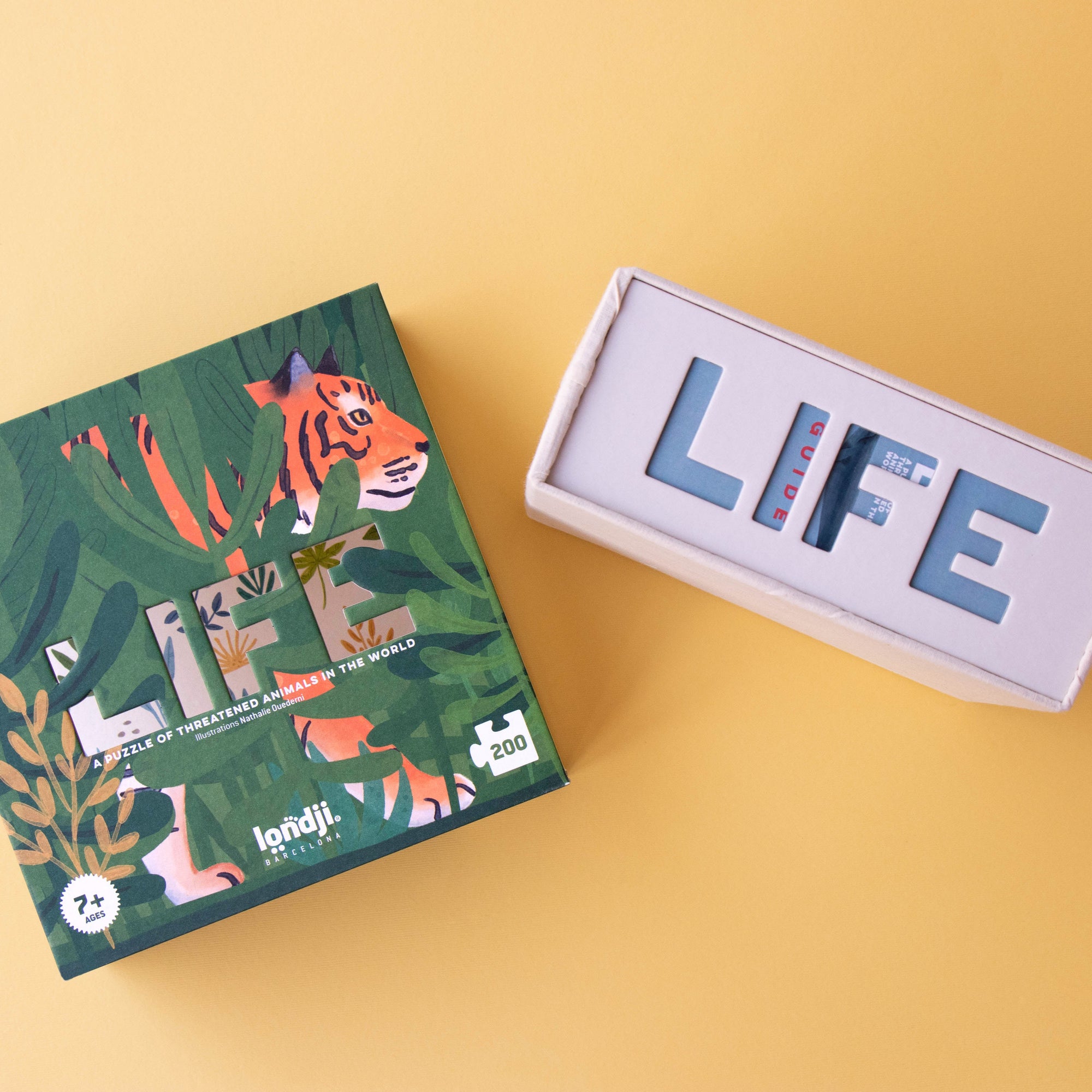 Two 'LIFE' board game boxes on a yellow background