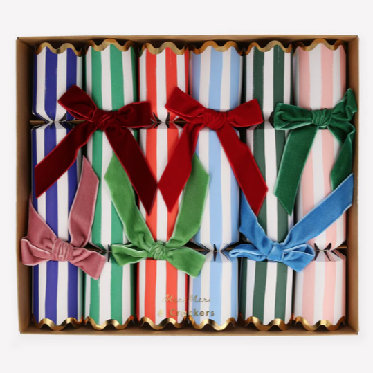 A set of Christmas crackers with striped patterns and velvet bows in various colors including red, green, and blue.