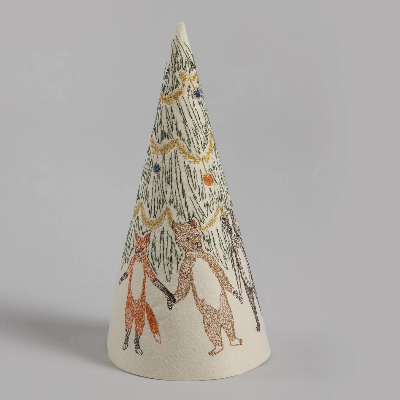 A beige felt Christmas tree decoration with animal illustrations and decorative details.