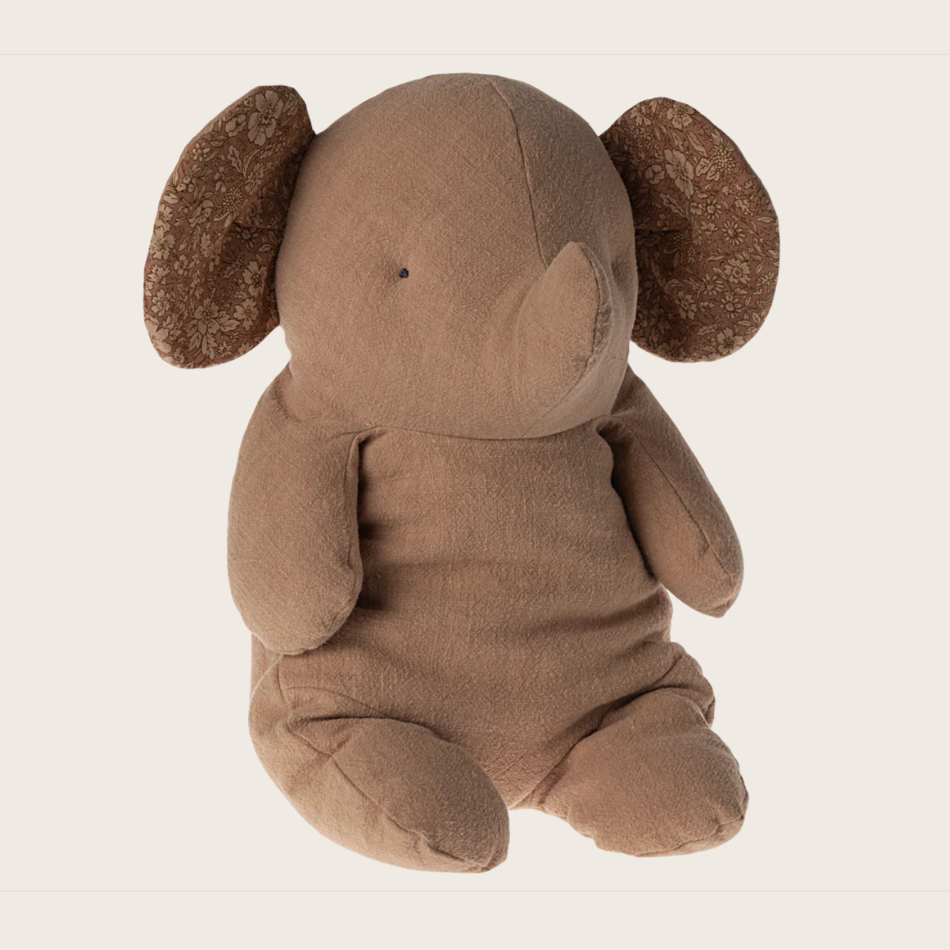 A beige plush elephant toy with a solid pattern.