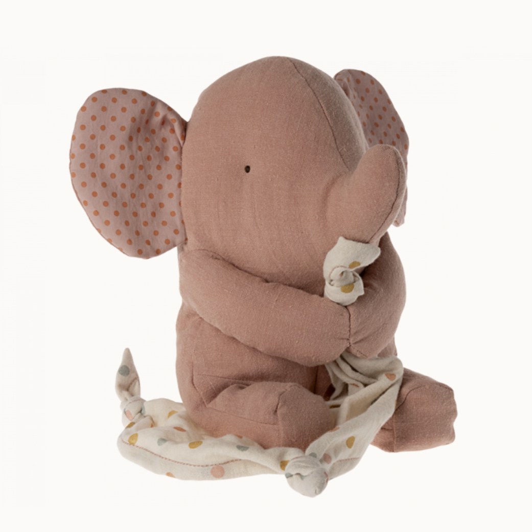 Stuffed elephant toy with a soft fabric in old rose color, with dotted patterns on its ears and a matching blanket.