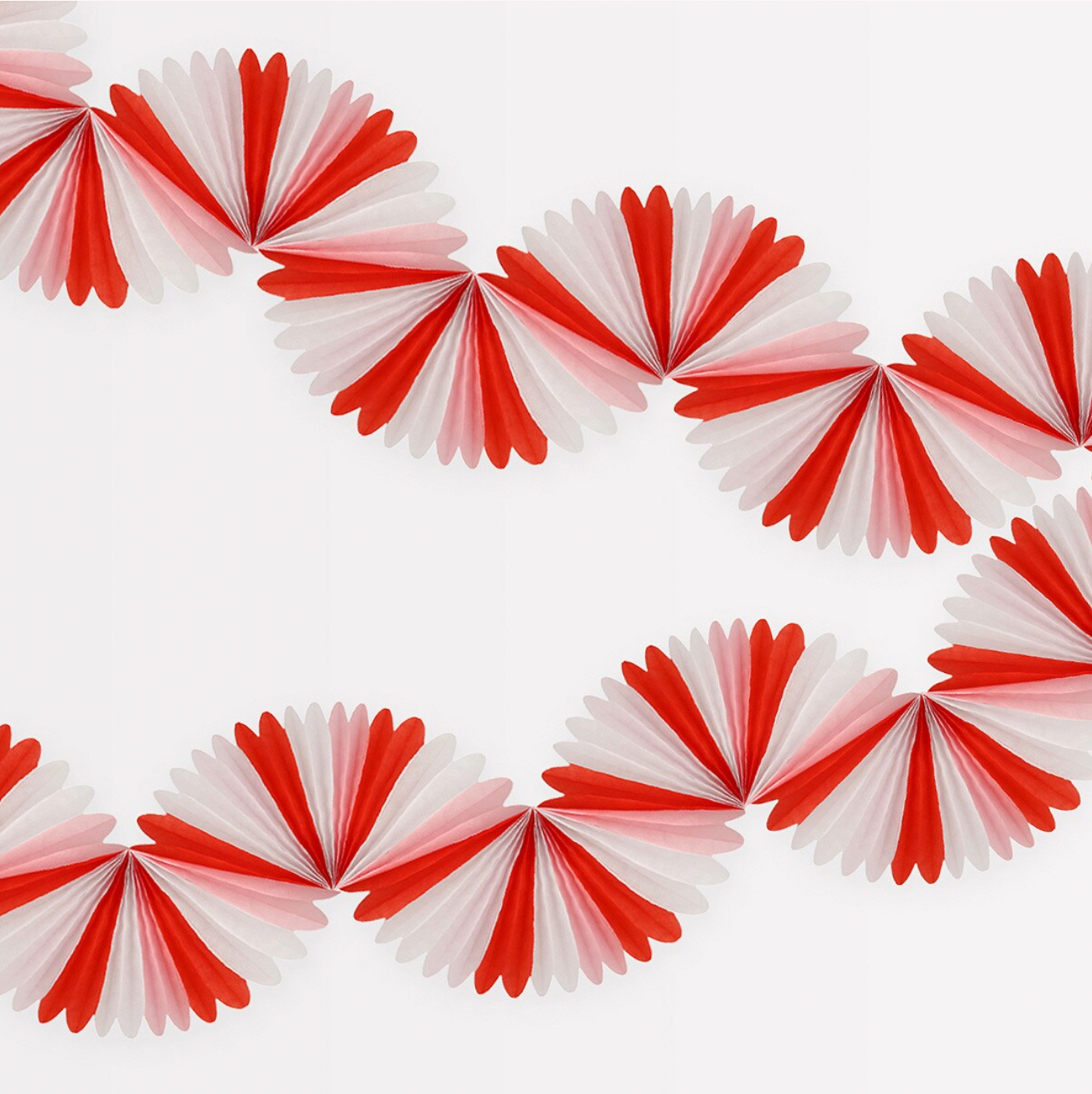 A festive Christmas garland with a candy cane stripe pattern in red, pink, and white, made of tissue paper honeycombs, with metallic gold cord for hanging.