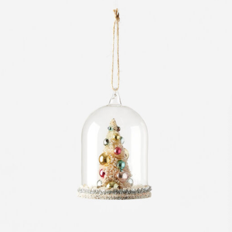 A Christmas tree ornament made of resin, designed to look like a tree inside a glass dome, decorated with multicolored bulbs and silver ribbon at the base.