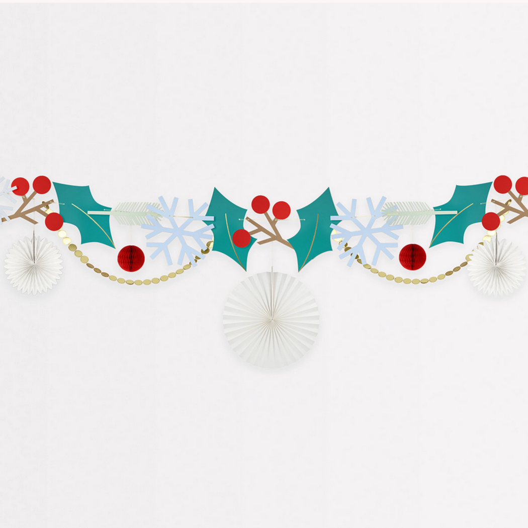 A festive Christmas garland decoration with a variety of paper decorations including sprigs, holly berries, leaves, snowflakes, red and white honeycomb tissue paper balls, and gold foil details.