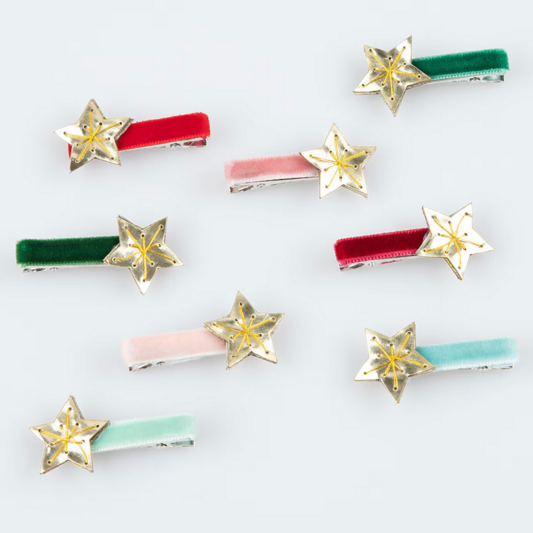A collection of eight hair clips with velvet ribbons and gold star decorations in various colors including red, pink, green, blue, and gold.