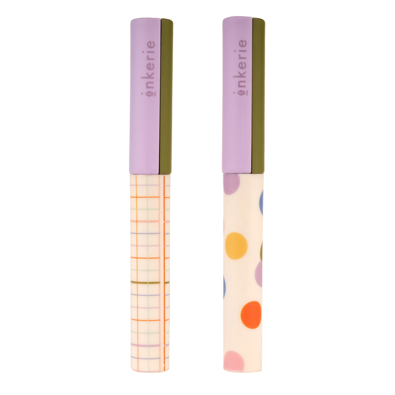 Two pocket scissors with purple and green handles, one with a dotted pattern and the other with a striped pattern on the blade.