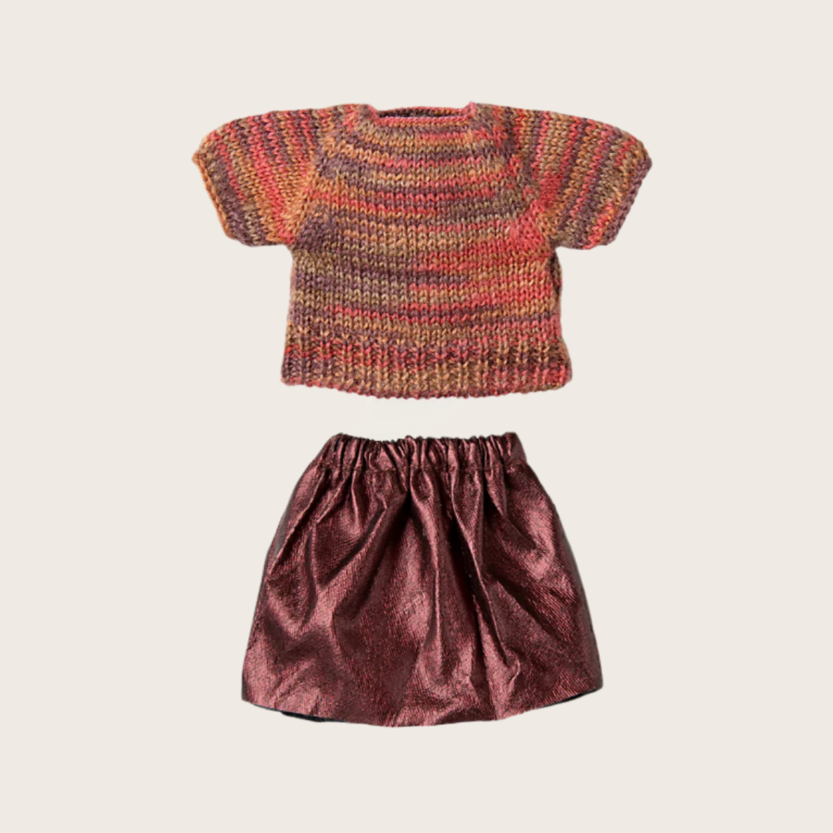 A multicolored knitted blouse and a pink skirt for a doll, placed on a plain background.