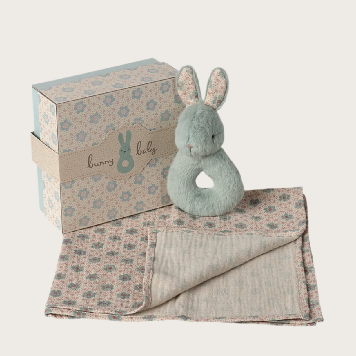 A soft blue rabbit rattle with a small rattle inside, accompanied by a soft cotton cloth with a floral pattern, packaged in a matching box with floral design.
