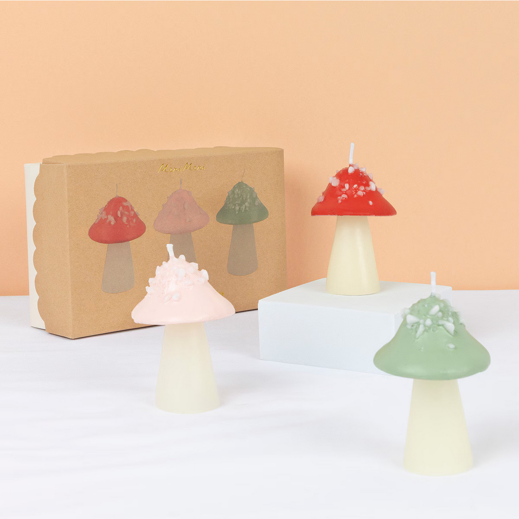 Mushroom-shaped candles with a cardboard box on a light background