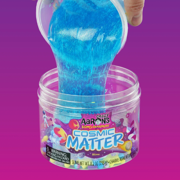 Blue slime being poured from a container labeled 'Cosmic Matter' by Crazy Aaron's Slime Charmers on a purple background.